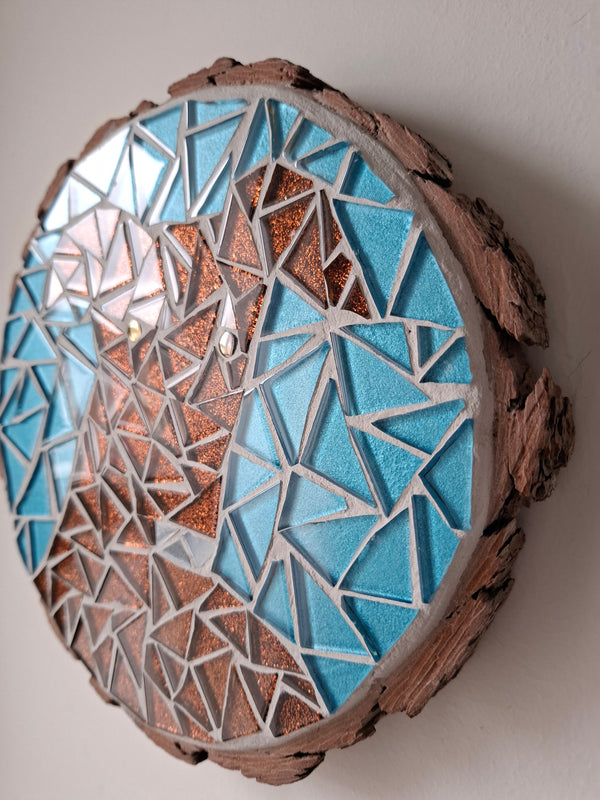 Side view of a circular dog mosaic artwork, showing the rustic wood edge.