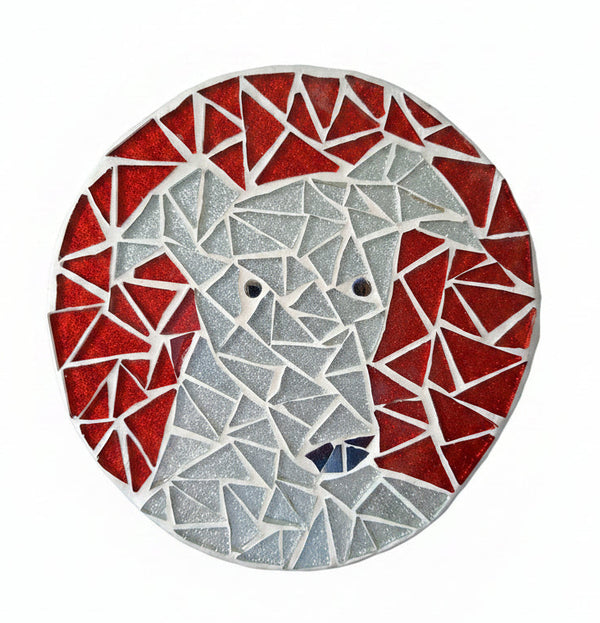 Circular mosaic wall art featuring a stylized dog design. Crafted with glittery silver glass pieces on a sparkly red background, set on rustic wood.