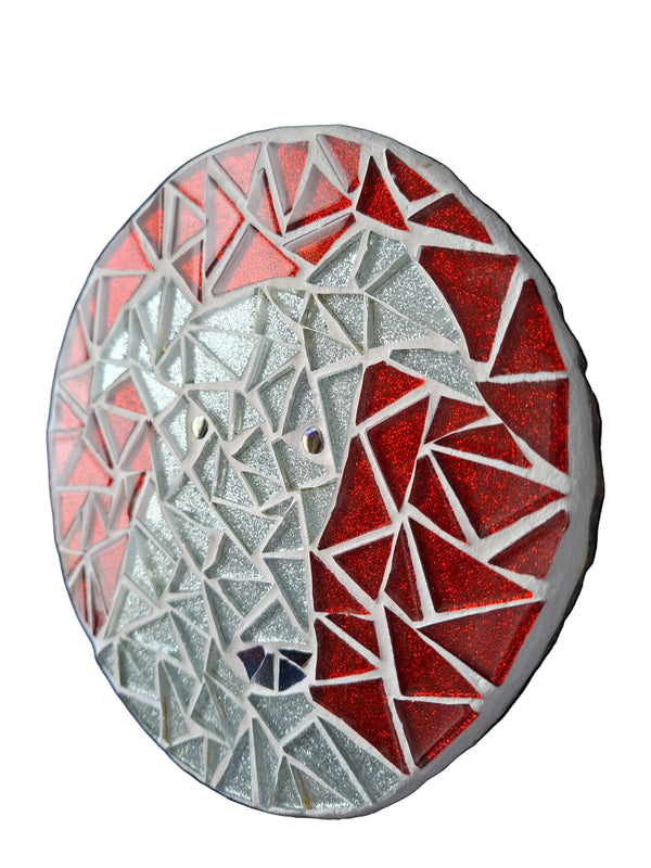 Side view of a circular dog mosaic artwork, showing the rustic wood edge.