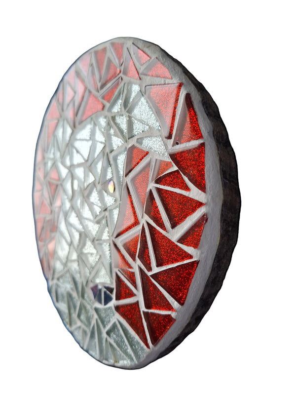 Side view of a circular dog mosaic artwork, showing the rustic wood edge.