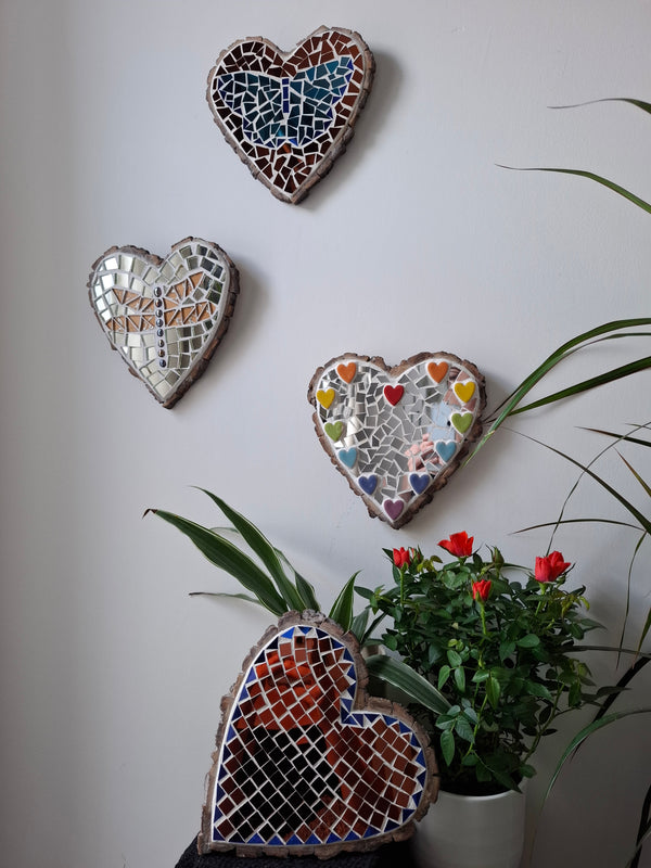 Heart shaped mosaics on the wall surrounded by plants