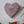 Heart mosaic on the wall surrounded by plants
