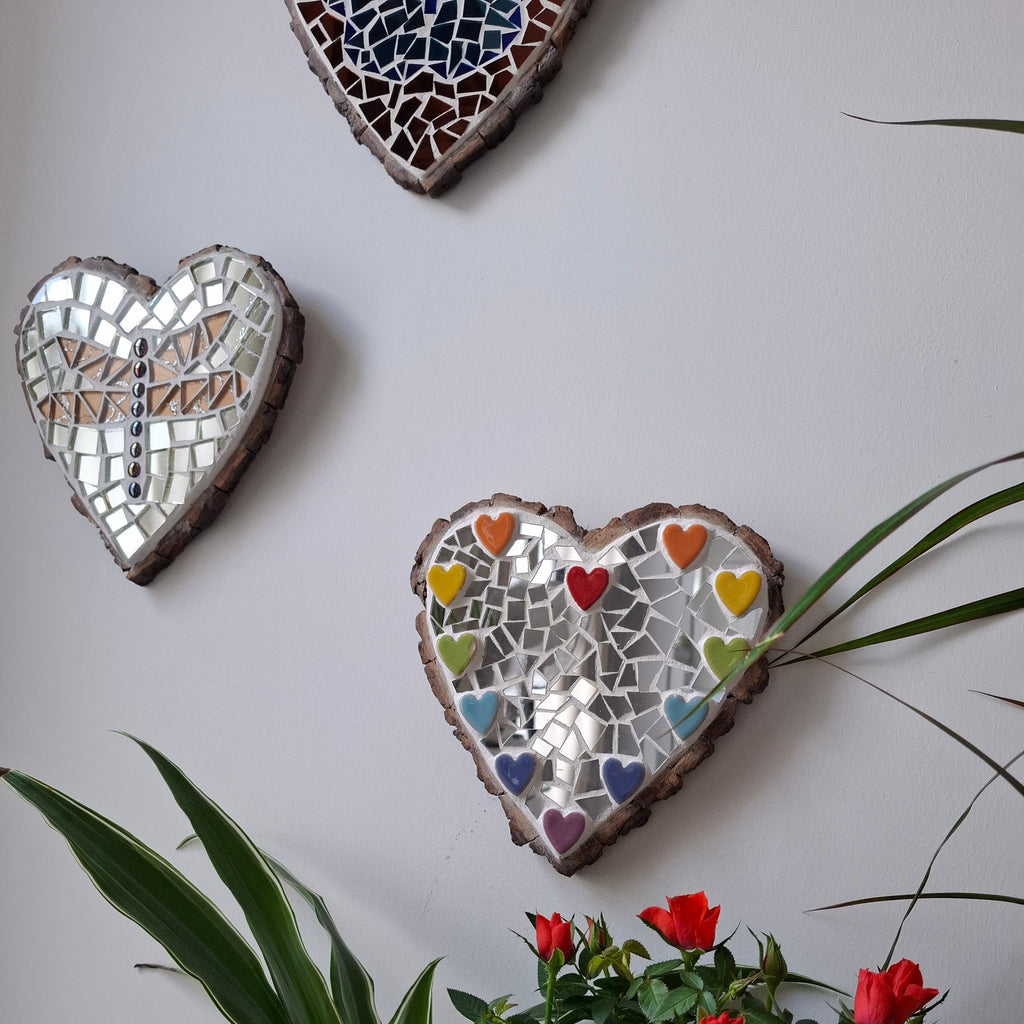 Heart mosaics on the wall surrounded by plants