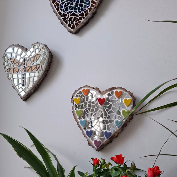 Heart mosaics on the wall surrounded by plants