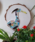 Heron mosaic on the wall surrounded by plants 