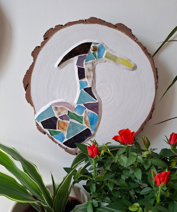 Heron mosaic on the wall surrounded by plants 