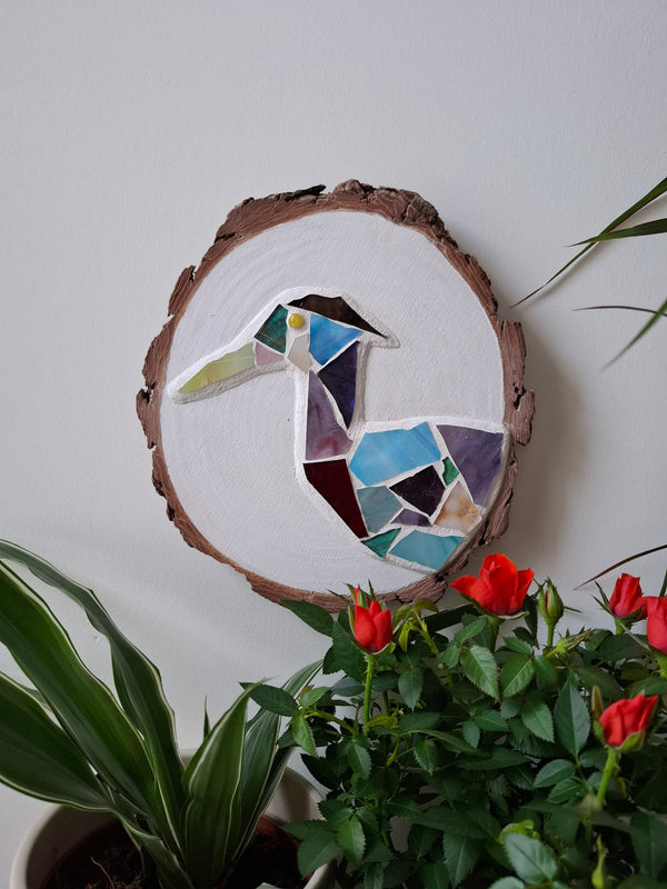 Heron mosaic on the wall surrounded by plants 