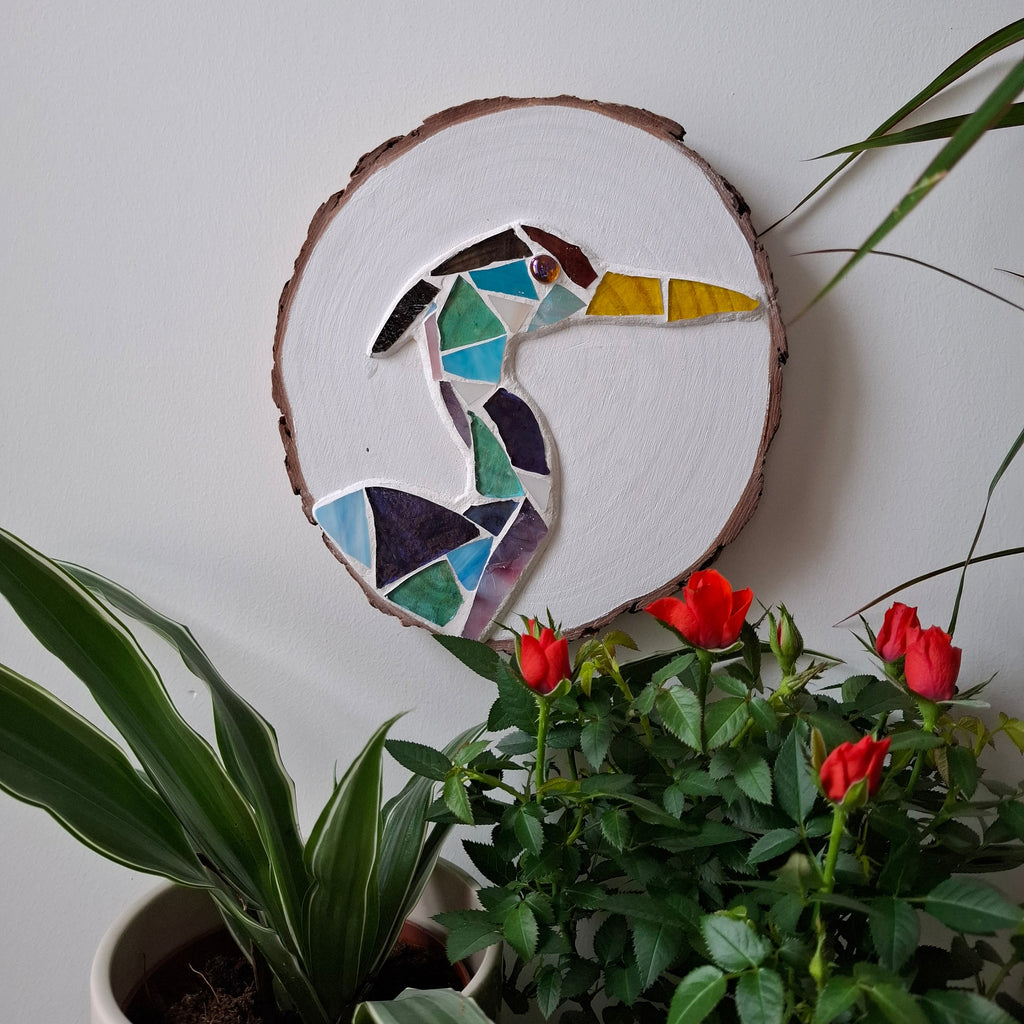 Heron mosaic on the wall surrounded by plants