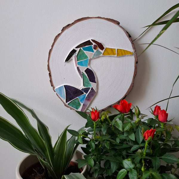 Heron mosaic on the wall surrounded by plants