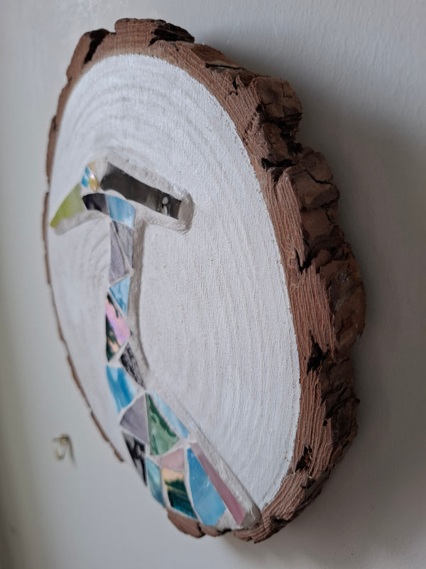 Side view of a circular heron mosaic artwork, showing the rustic wood ed