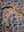 Side view of a circular heron mosaic artwork, showing the rustic wood edge.