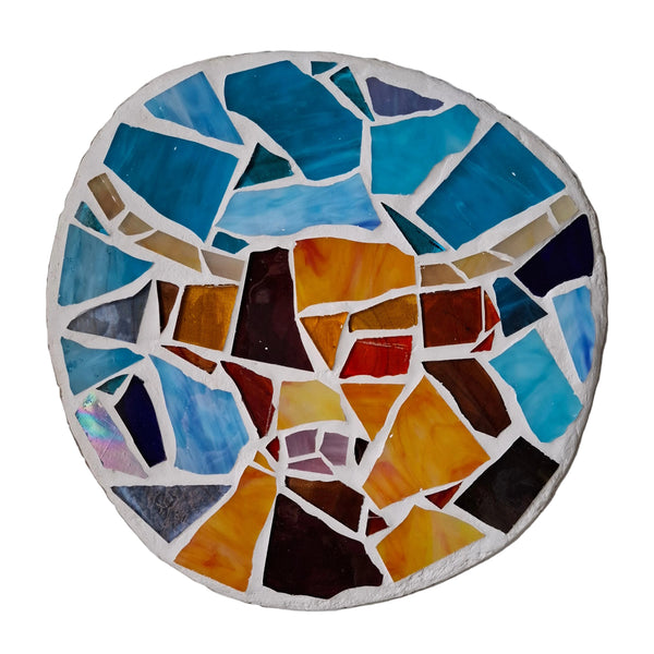 Circular mosaic wall art featuring a stylized highland cow design. Crafted with orange and brown stained glass pieces on a blue background, set on rustic wood.
