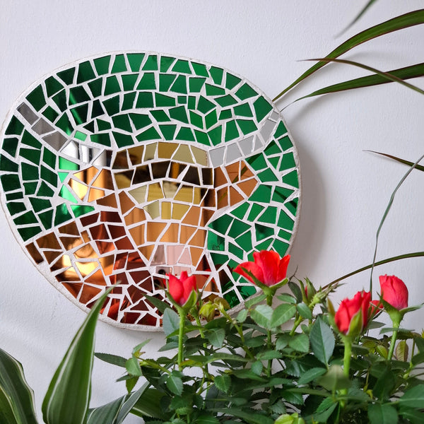 Highland cow mosaic on the wall surrounded by plants 