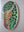 Side view of a circular highland cow mosaic artwork, showing the rustic wood edge.