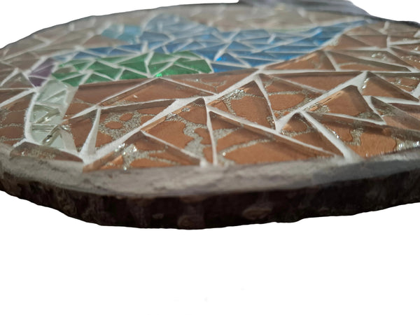 Side view of a circular bird mosaic artwork, showing the rustic wood edge.