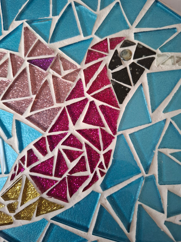 Close up of a circular bird mosaic artwork, showing the rustic wood edge.
