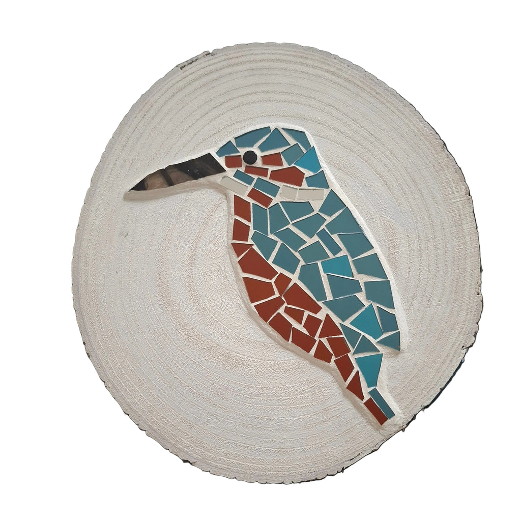 Circular mosaic wall art featuring a stylized kingfisher design. Crafted with reflective blue and orange mirror glass pieces on a painted white background, set on rustic wood.
