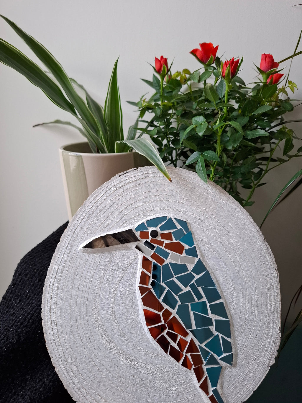 Kingfisher mosaic on the table surrounded by plants