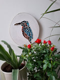 Kingfisher mosaic on the wall surrounded by plants