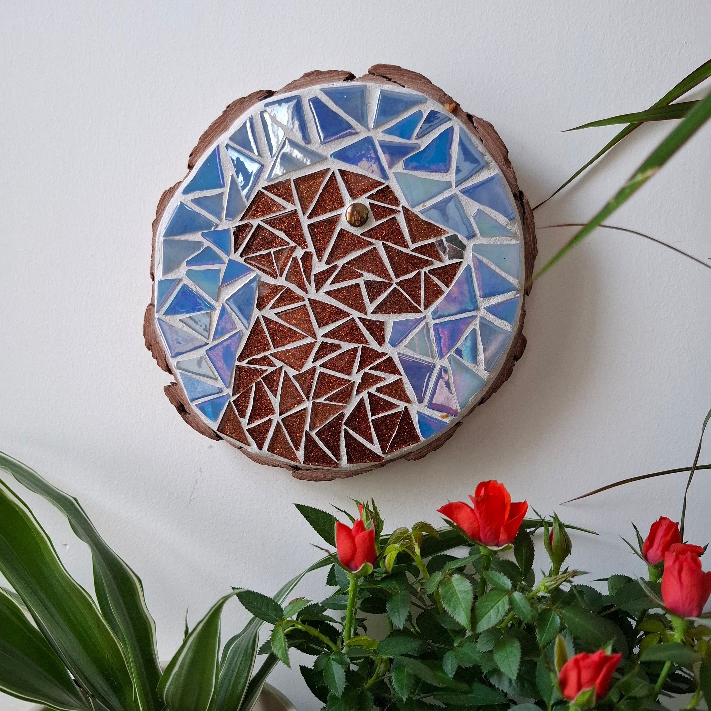 Dog mosaic on the wall surrounded by plants
