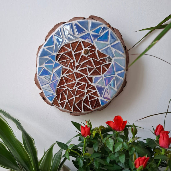 Dog mosaic on the wall surrounded by plants
