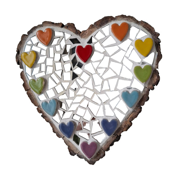 Heart shaped mosaic wall art featuring a colourful heart design. Crafted with a colourful ceramic heart border and reflective silver mirror glass pieces, set on rustic wood.