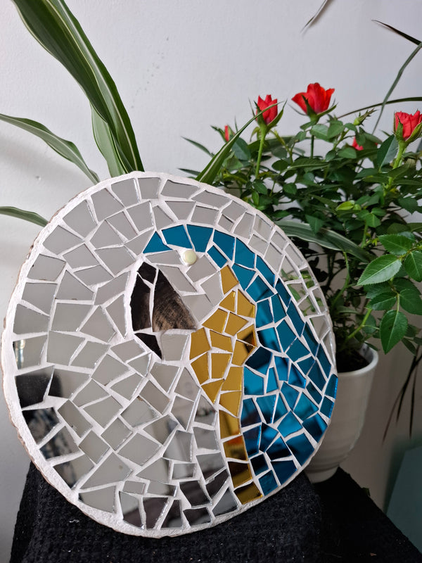 Macaw mosaic on the table surrounded by plants 