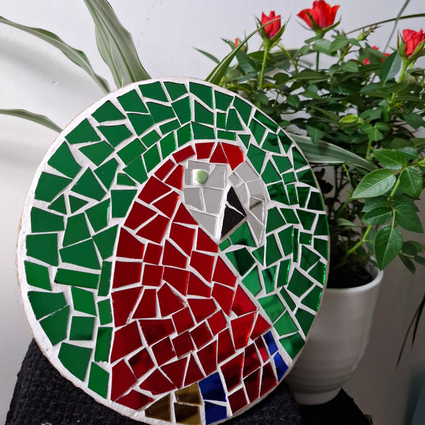 Macaw mosaic on the table surrounded by plants 