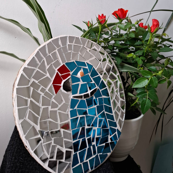 Parakeet mosaic on the table surrounded by plants 