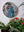 Parakeet mosaic on the wall surrounded by plants 