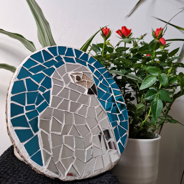 Parrot mosaic on the table surrounded by plants 
