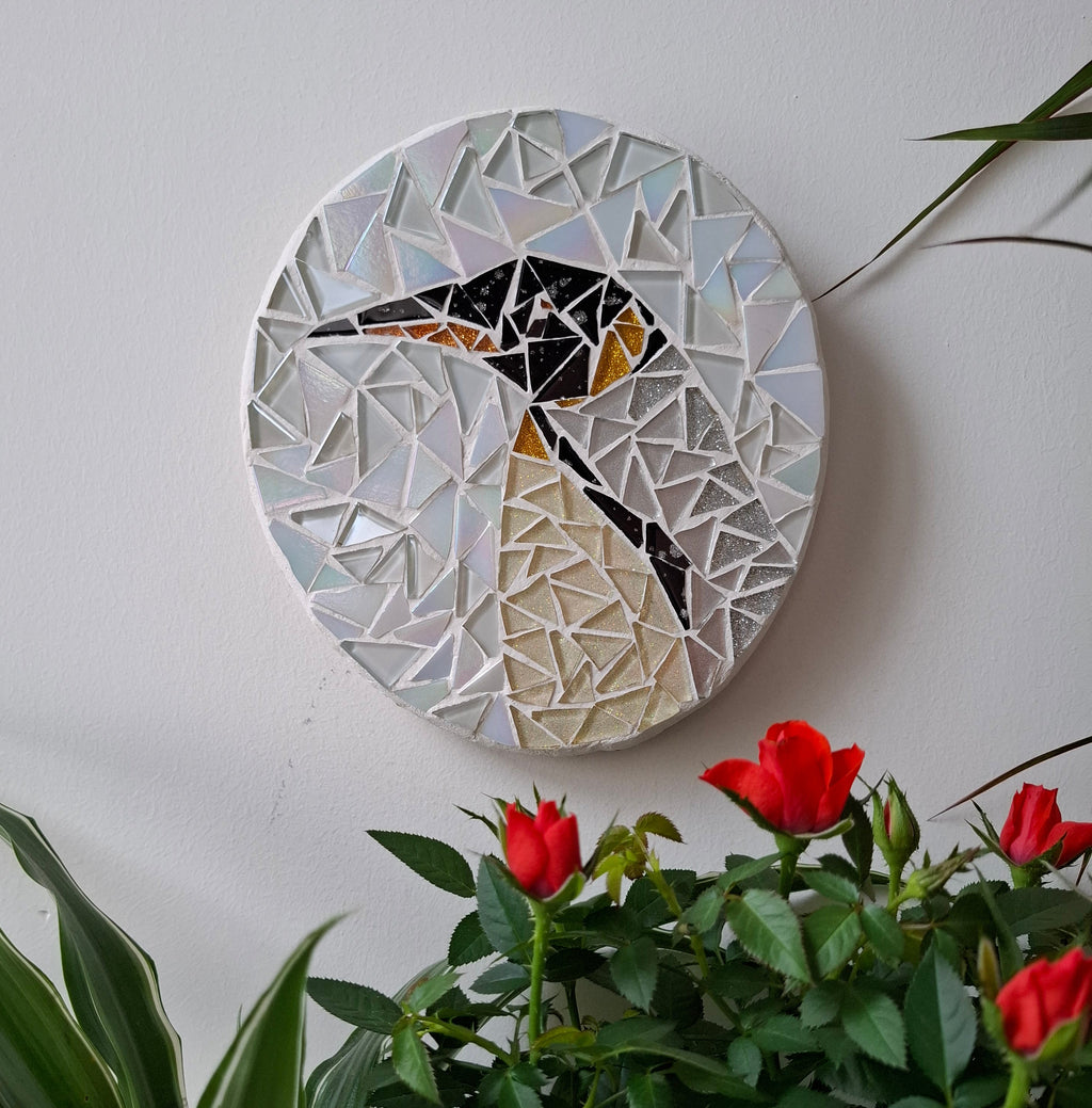 Penguin mosaic on the wall surrounded by plants
