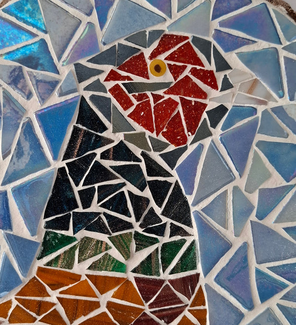 Close up of a circular pheasant mosaic artwork, showing the rustic wood edge.