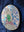 Side view of a circular pigeon mosaic artwork, showing the rustic wood edge.