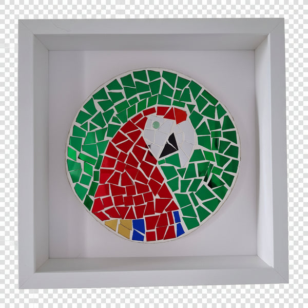 A circular mosaic wall art piece depicting a parrot, mounted inside a square white shadow box frame against a white wall.