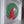 A circular mosaic wall art piece depicting a parrot, mounted inside a white frame. The parrot design features green, red, white, yellow, and blue mosaic tiles.