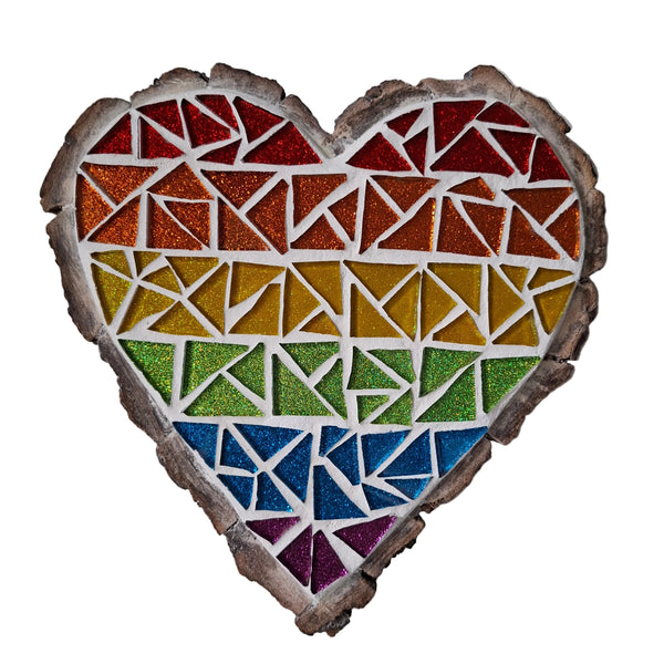 Heart shaped mosaic wall art featuring a glittery pride rainbow design. Crafted with colourful sparkly glass pieces, set on rustic wood.