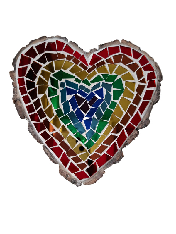 Heart shaped mosaic wall art featuring a rainbow mirror design. Crafted with reflective colouful mirror glass pieces, set on rustic wood.
