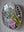 Side view of a circular parakeet mosaic artwork, showing the rustic wood edge.