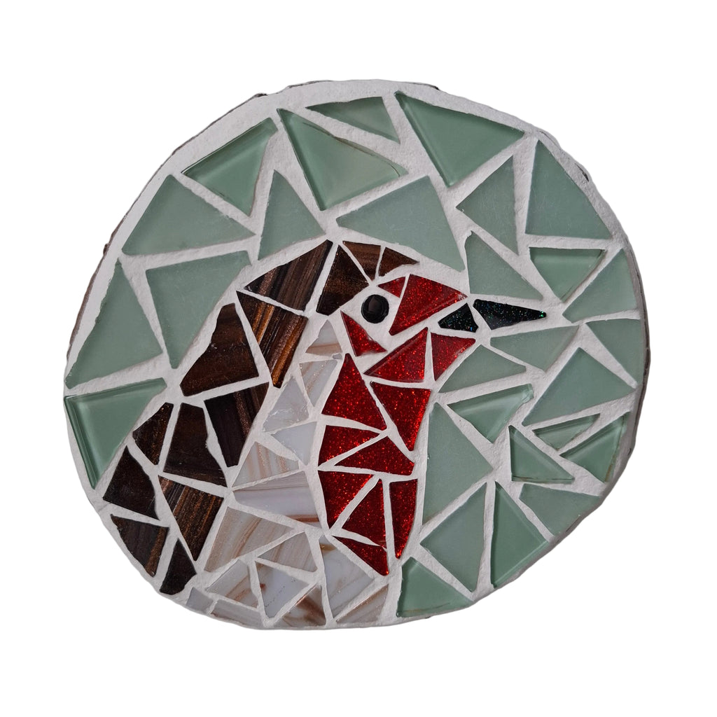 Circular mosaic wall art featuring a stylized robin design. Crafted with white, red, and brown glass pieces on a frosted aqua background, set on rustic wood.