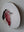 Side view of a circular robin mosaic artwork, showing the rustic wood edge.