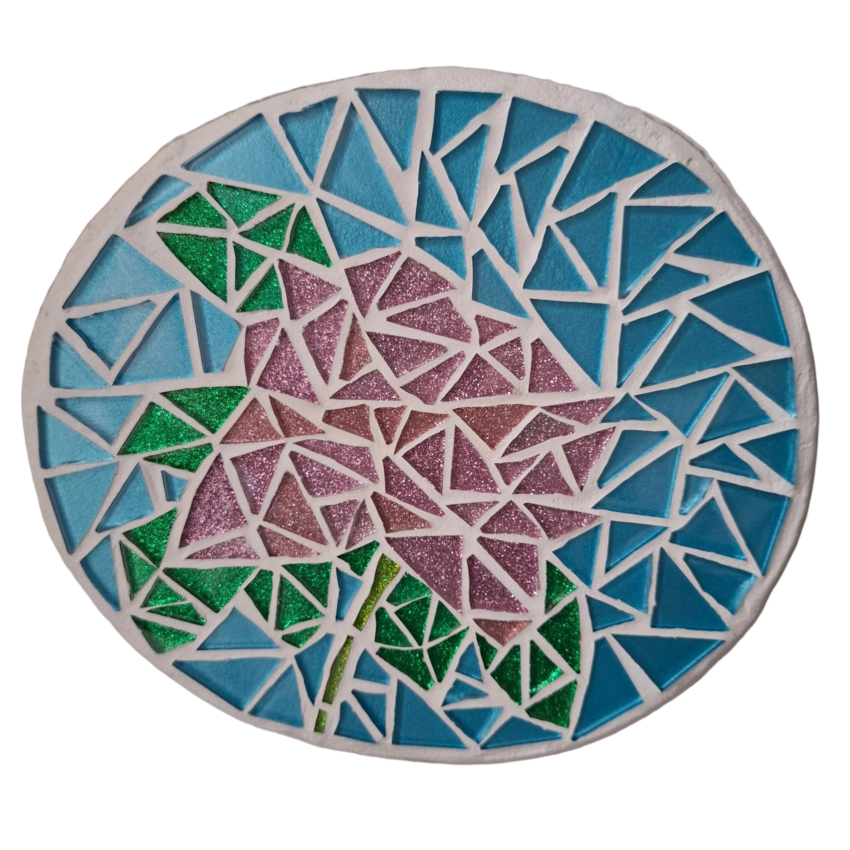 Circular mosaic wall art featuring a stylized rose design. Crafted with pink and green glittery glass pieces on a sparkling blue background, set on rustic wood.