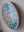 Side view of a circular mosaic rose artwork, showing the rustic wood edge.