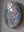 Side view of a circular snowdrop mosaic artwork, showing the rustic wood edge.