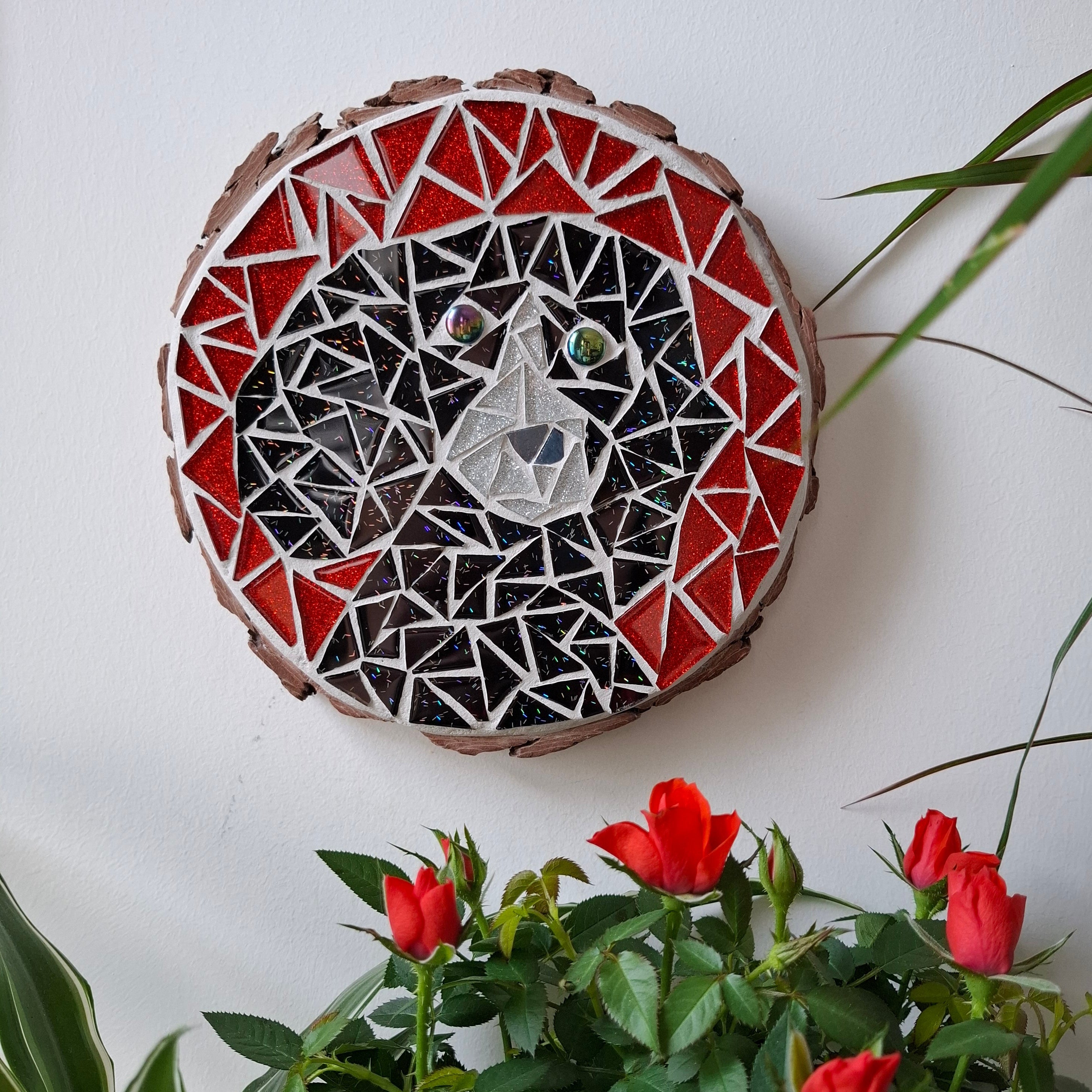 Dog mosaic on the wall surrounded by plants
