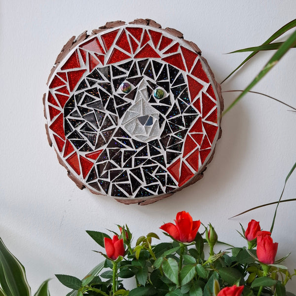 Dog mosaic on the wall surrounded by plants
