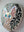 Side view of a circular cat mosaic artwork, showing the rustic wood edge.