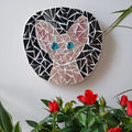 Cat mosaic on the wall surrounded by plants
