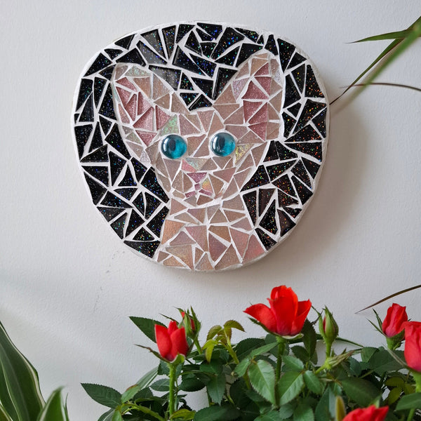 Cat mosaic on the wall surrounded by plants
