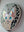 Side view of a circular cat mosaic artwork, showing the rustic wood edge.